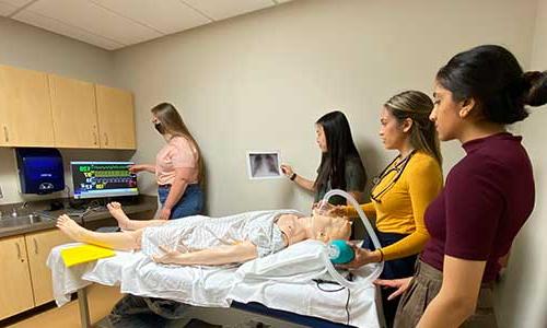 a group of 博天堂官方入口登陆登录 students practicing in a patient room.